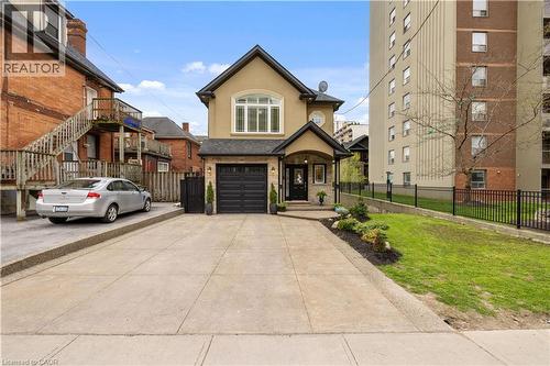 Stucco exterior with stone accents, a single-car garage, and a covered front entry - 199 Hunter Street W, Hamilton, ON - Outdoor With Facade