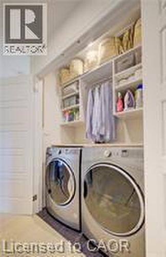 Dedicated laundry area featuring built-in shelving, hanging rod, and white flat-panel doors - 290 William Street, Elmira, ON - Indoor Photo Showing Laundry Room