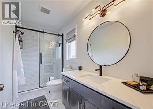 Modern bathroom featuring a single vanity with dark wood-finish cabinetry, a rectangular undermount sink, and a white countertop - 290 William Street, Elmira, ON - Indoor Photo Showing Bathroom