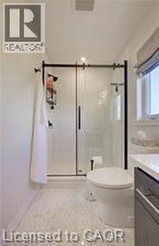 Contemporary bathroom featuring a frameless glass shower enclosure with matte black hardware, white subway tile shower surround, and hexagonal floor tiles - 290 William Street, Elmira, ON - Indoor Photo Showing Bathroom