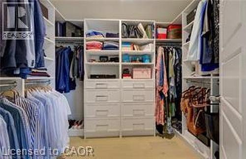 Custom closet system featuring extensive shelving, multiple hanging rods, and integrated drawers - 290 William Street, Elmira, ON - Indoor With Storage
