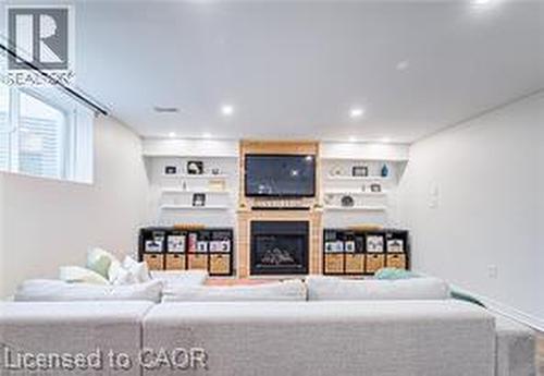 Recessed lighting illuminates a feature wall with a wood-finish mantel and integrated fireplace - 290 William Street, Elmira, ON - Indoor With Fireplace