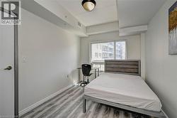 Bright room with a large window, light wood-finish flooring, and a white interior door - 