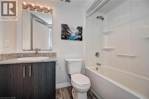 Bathroom featuring a dark wood-finish vanity with a granite-style countertop and an undermount sink - 275 Larch Street Unit# F209, Waterloo, ON - Indoor Photo Showing Bathroom