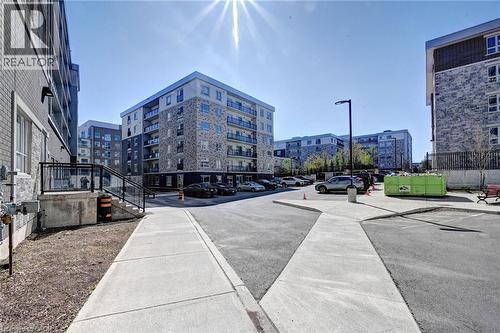 Modern apartment buildings featuring stone and brick facades, private balconies, on-site parking, and well-defined concrete walkways - 275 Larch Street Unit# F209, Waterloo, ON - Outdoor