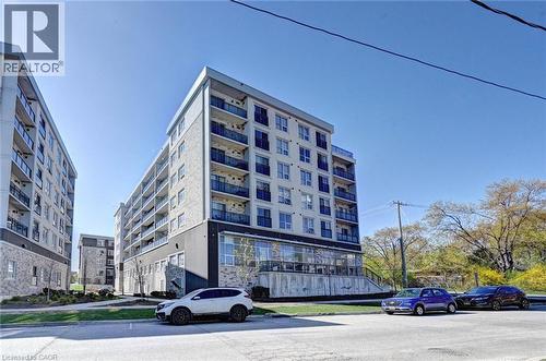 Modern multi-story building featuring a light-colored facade with stone accents and multiple balconies - 275 Larch Street Unit# F209, Waterloo, ON - Outdoor With Balcony With Facade