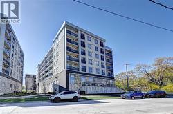 Modern multi-story building featuring a light-colored facade with stone accents and multiple balconies - 