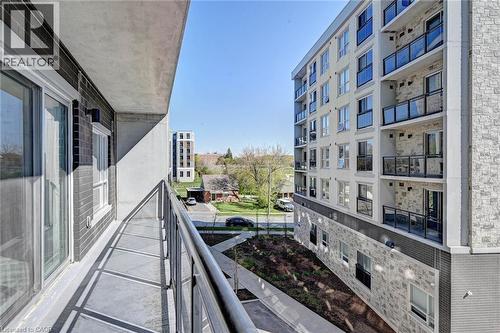 Spacious concrete balcony with metal railings and sliding glass doors - 275 Larch Street Unit# F209, Waterloo, ON - Outdoor