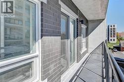 Balcony featuring a metal railing, concrete flooring, and dark brick exterior - 
