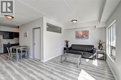 Open-concept living space featuring light wood-finish flooring, white baseboards, and neutral wall paint - 