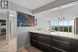 Kitchen island featuring dark wood-finish cabinetry with linear pulls and a light-toned countertop - 