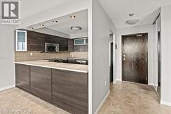 Kitchen with wood-finish cabinetry, light-toned countertops, and recessed lighting - 