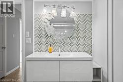 Contemporary vanity featuring a white integrated sink, chrome faucet, and glossy white cabinetry - 
