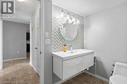 Floating vanity with an integrated basin, mosaic tile backsplash, and a round mirror with etched detailing - 