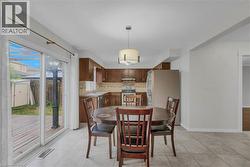 Kitchen and dining area featuring wood cabinetry, stainless steel appliances, and a tiled backsplash - 