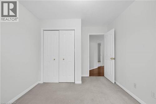 Neutral-toned room featuring light gray walls, plush gray carpeting, and white trim - 888 Paisley Road, Guelph, ON - Indoor