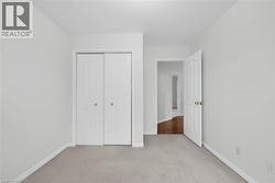 Neutral-toned room featuring light gray walls, plush gray carpeting, and white trim - 