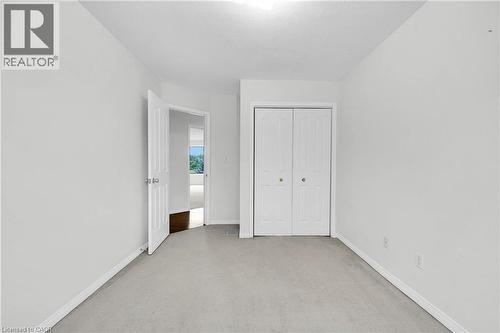 Carpeted room featuring white walls and a closet with bifold doors - 888 Paisley Road, Guelph, ON - Indoor Photo Showing Other Room