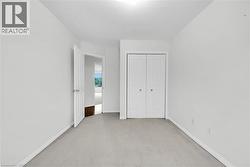 Carpeted room featuring white walls and a closet with bifold doors - 