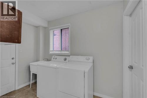 Dedicated laundry area featuring a utility sink, tiled flooring, and a window with blinds - 888 Paisley Road, Guelph, ON - Indoor Photo Showing Laundry Room