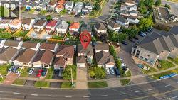Residential property featuring a driveway, attached garage, and mature landscaping - 