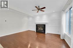 Living area featuring wood-finish flooring and a white paneled accent wall with a built-in fireplace - 