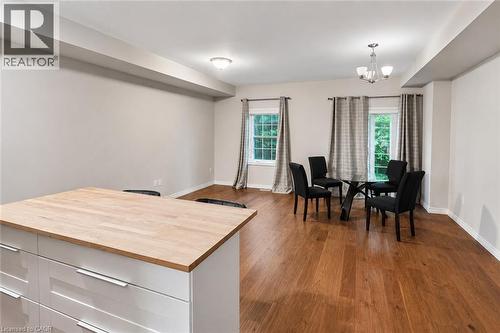 Open-concept living area featuring rich wood-finish flooring, white baseboards, and neutral wall tones - 133 St Leger Street, Kitchener, ON - Indoor Photo Showing Dining Room