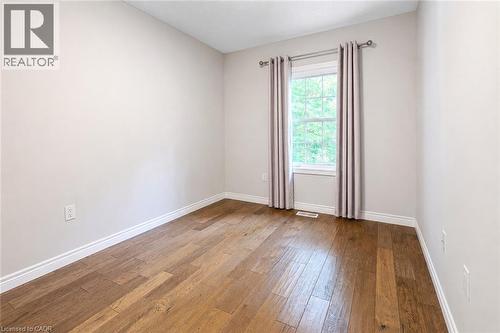 Interior room featuring wood-finish flooring, light neutral-toned walls, and white baseboards - 133 St Leger Street, Kitchener, ON - Indoor Photo Showing Other Room