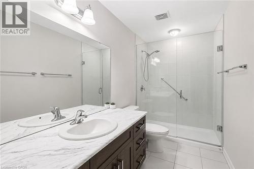 Bathroom vanity with dual undermount sinks and a marble-finish countertop - 133 St Leger Street, Kitchener, ON - Indoor Photo Showing Bathroom