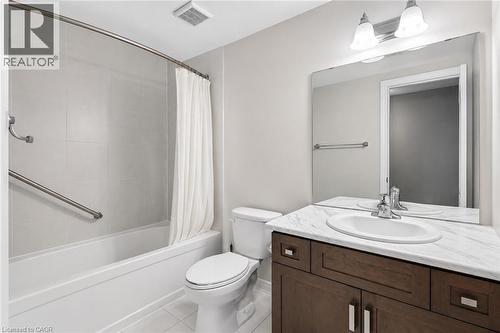 Bathroom featuring a dark wood-finish vanity with an undermount sink, a white countertop, and a large wall-mounted mirror - 133 St Leger Street, Kitchener, ON - Indoor Photo Showing Bathroom