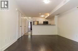 Open-concept living area with dark wood-finish flooring - 