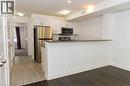 Kitchenette featuring white cabinetry, stainless steel appliances, dark countertops, and a breakfast bar - 190 Century Hill Drive Unit# A5, Kitchener, ON  - Indoor Photo Showing Kitchen 