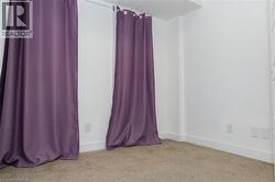 Carpeted room with white walls, baseboards, and two electrical outlets - 
