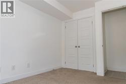 Room featuring white walls and neutral carpet flooring - 