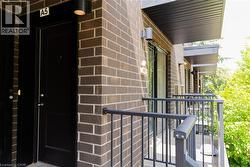 Exterior brick facade featuring a private balcony with black metal railings - 