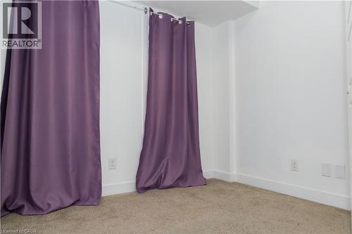 Carpeted room with white walls, baseboards, and two electrical outlets - 190 Century Hill Drive Unit# A5, Kitchener, ON - Indoor
