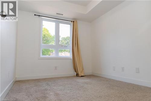 Carpeted room featuring a large window with white framing and a black curtain rod - 190 Century Hill Drive Unit# A5, Kitchener, ON - Indoor Photo Showing Other Room