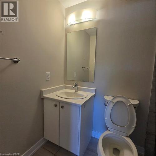 Bathroom vanity featuring a white cabinet, integrated sink, and chrome faucet - 20 Palace Place Unit# E9, Kitchener, ON - Indoor Photo Showing Bathroom