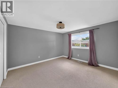 Carpeted room with a window providing natural light, grey painted walls, white trim, and a semi-flush ceiling fixture - 143 Cromwell Crescent, Hamilton, ON - Indoor Photo Showing Other Room