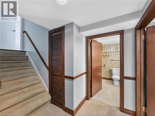 Carpeted staircase with wooden handrail, leading to an upper level - 143 Cromwell Crescent, Hamilton, ON - Indoor Photo Showing Other Room