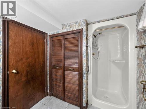 White shower enclosure featuring a curved grab bar and integrated shelving - 143 Cromwell Crescent, Hamilton, ON - Indoor Photo Showing Bathroom
