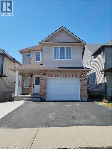 Two-story residence featuring light-colored siding, brick accents, an attached two-car garage, multiple windows, and a covered front porch with a white column - 110 Iron Gate Street, Kitchener, ON 
