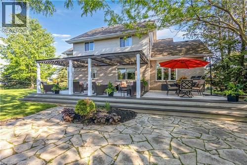 Multi-level rear deck with a pergola-covered section and an expansive flagstone patio - 25 Brian Drive, Burford, ON - Outdoor With Deck Patio Veranda