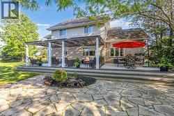 Multi-level rear deck with a pergola-covered section and an expansive flagstone patio - 