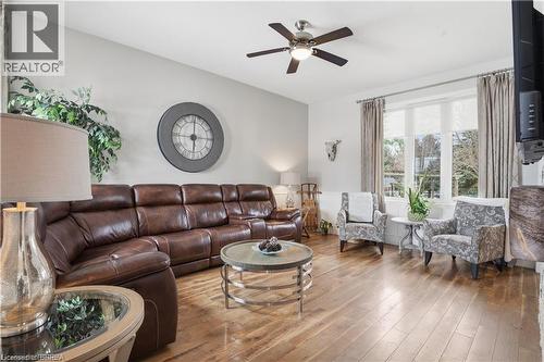 Spacious living area featuring wood-finish flooring, a ceiling fan with integrated lighting, and large windows with privacy blinds - 25 Brian Drive, Burford, ON - Indoor Photo Showing Living Room