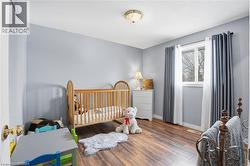 Well-lit room featuring wood-finish flooring and a single window with white trim - 