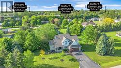 Spacious property featuring a large residence, expansive green lawn, mature trees, and an asphalt driveway - 