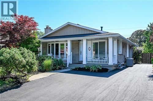 Brick and siding exterior with a covered front porch featuring white columns and railing - 101 Loyalist Drive, Hamilton, ON - Outdoor With Deck Patio Veranda