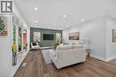 Living area featuring wood-finish flooring, a prominent bay window, recessed lighting, white baseboards, and a contrasting accent wall - 101 Loyalist Drive, Hamilton, ON  - Indoor Photo Showing Living Room 
