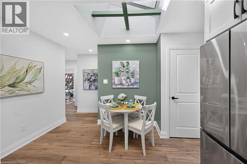 Dining area featuring a skylight with exposed beams, wood-finish flooring, recessed lighting, and a contrasting accent wall - 101 Loyalist Drive, Hamilton, ON - Indoor Photo Showing Other Room